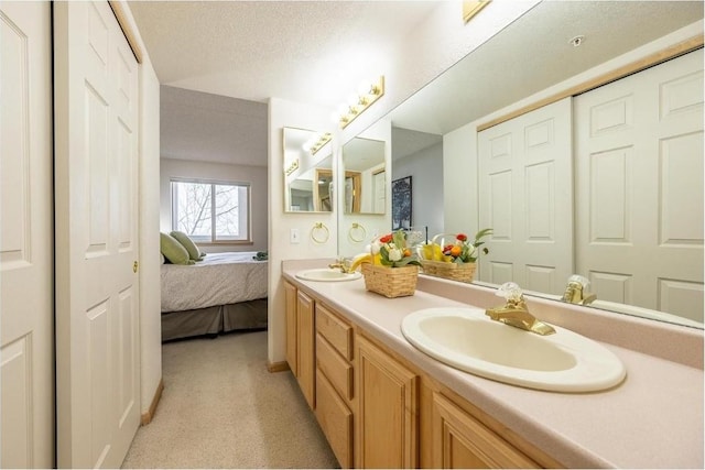 bathroom featuring ensuite bathroom, a sink, and double vanity