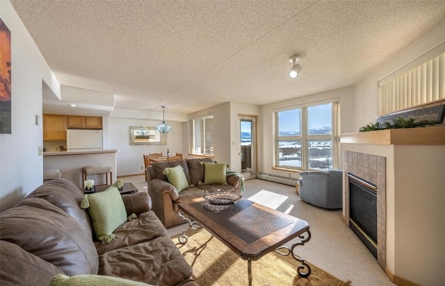 living room with a tile fireplace, a water view, a baseboard heating unit, a textured ceiling, and light colored carpet