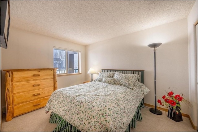 bedroom with baseboards, carpet floors, and a textured ceiling