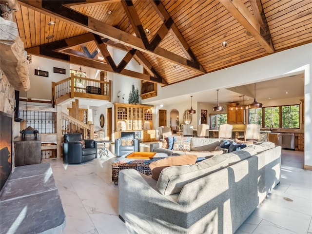 59 Mountain Bluebell Rd, Keystone, CO 80435 - living room with wooden ceiling with exposed beams, light marble finish floors, high vaulted ceiling, stairway, and arched walkways