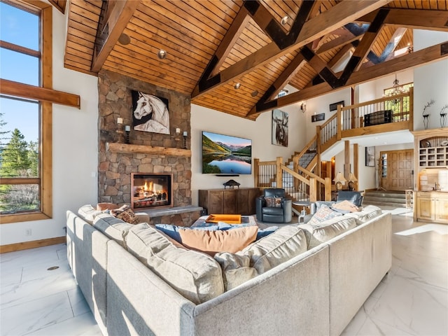 59 Mountain Bluebell Rd, Keystone, CO 80435 - living area with marble finish floors, stairway, wooden ceiling with exposed beams, a stone fireplace, and baseboards