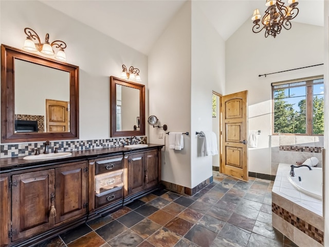 59 Mountain Bluebell Rd, Keystone, CO 80435 - full bath with baseboards, double vanity, a bath, stone tile flooring, and decorative backsplash