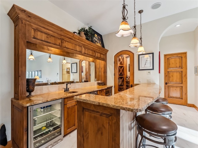 59 Mountain Bluebell Rd, Keystone, CO 80435 - indoor wet bar with wine cooler, arched walkways, decorative light fixtures, and light marble finish floors