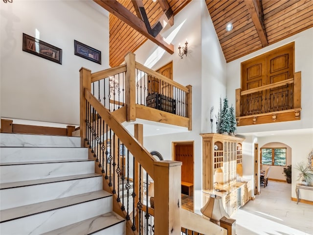 59 Mountain Bluebell Rd, Keystone, CO 80435 - stairs with high vaulted ceiling, wooden ceiling with exposed beams, arched walkways, and baseboards