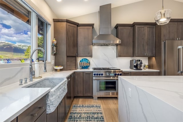456 Forest Hills Dr, Breckenridge, CO 80424 - kitchen with appliances with stainless steel finishes, wall chimney range hood, light wood-style flooring, vaulted ceiling, and light stone countertops