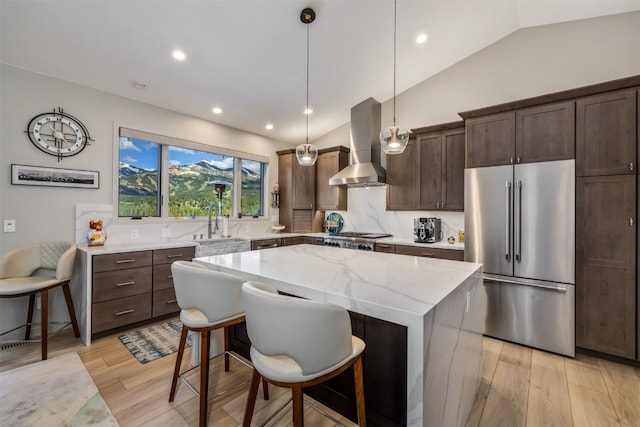 456 Forest Hills Dr, Breckenridge, CO 80424 - kitchen with high end fridge, wall chimney exhaust hood, vaulted ceiling, a kitchen island, and dark brown cabinetry