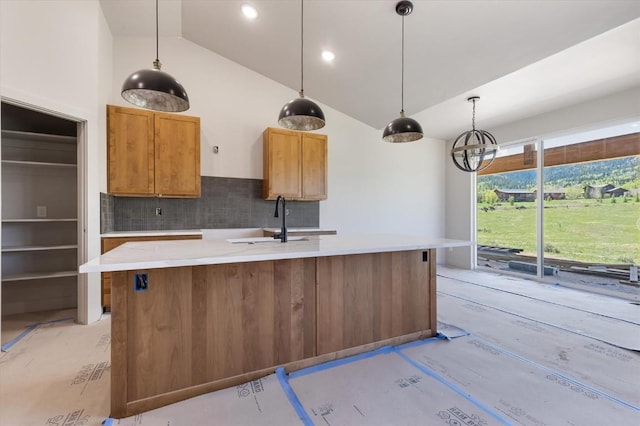30350 Hostler Dr, Oak Creek, CO 80467 - kitchen with backsplash, a sink, a kitchen island with sink, decorative light fixtures, and high vaulted ceiling