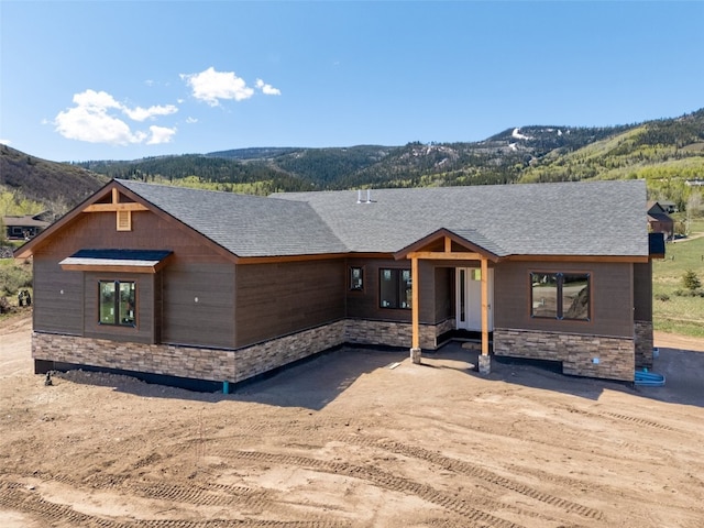 30350 Hostler Dr, Oak Creek, CO 80467 - view of front of property with stone siding, a mountain view, and roof with shingles