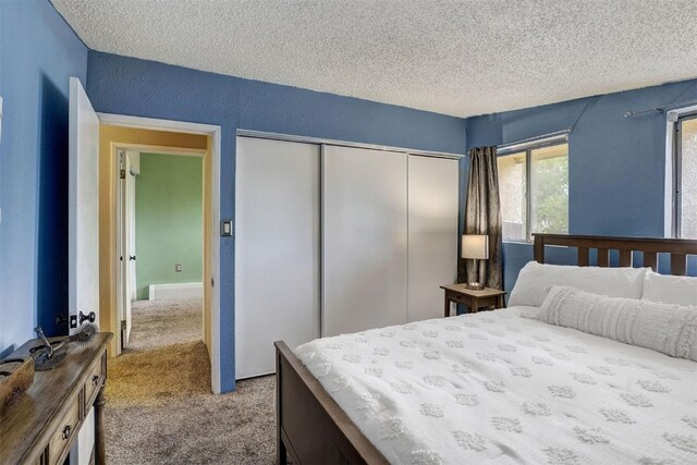 carpeted bedroom featuring a closet and a textured ceiling