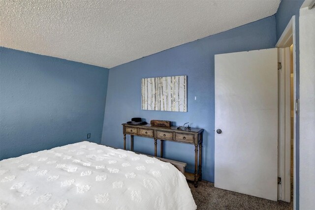 bedroom featuring a textured ceiling, carpet floors, and vaulted ceiling