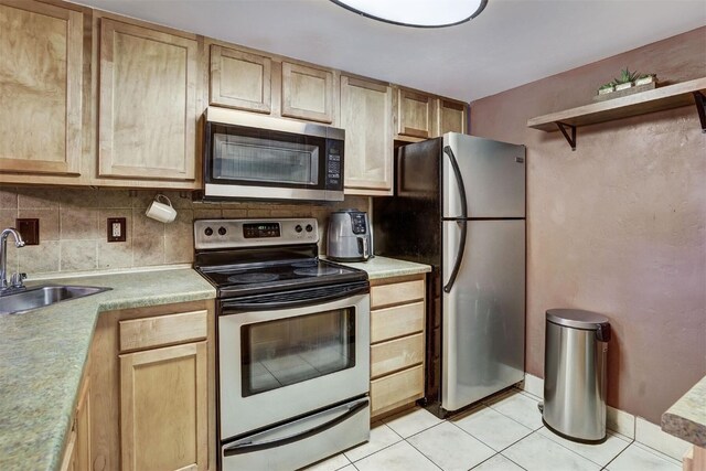 kitchen with decorative backsplash, appliances with stainless steel finishes, sink, light brown cabinets, and light tile patterned floors