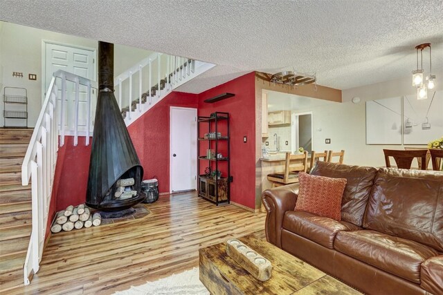 living room featuring sink, a textured ceiling, and hardwood / wood-style flooring