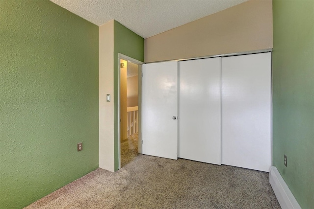 unfurnished bedroom featuring carpet flooring, a textured ceiling, and a closet