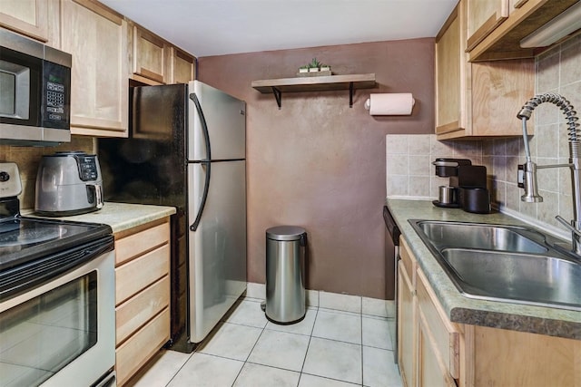 kitchen featuring appliances with stainless steel finishes, tasteful backsplash, sink, light brown cabinets, and light tile patterned floors