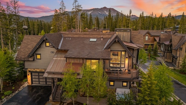 128 Union Trl, Breckenridge, CO 80424 - view of front facade with a mountain view, asphalt driveway, a garage, and a balcony