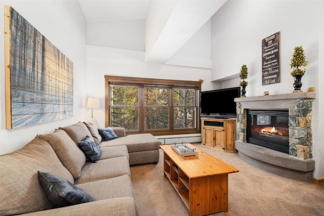 living room featuring a baseboard heating unit, a stone fireplace, a towering ceiling, and light colored carpet