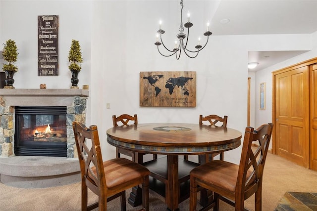 dining room with carpet flooring, a fireplace, and a chandelier