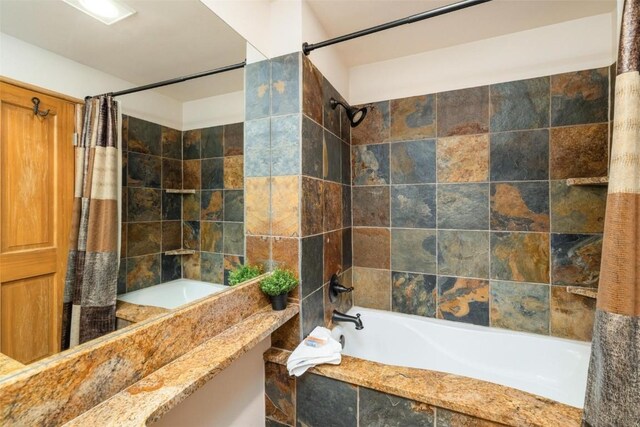 bathroom with tile walls and shower / bathtub combination with curtain