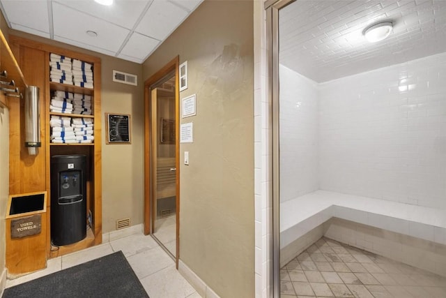 bathroom with visible vents, tile patterned flooring, and tiled shower