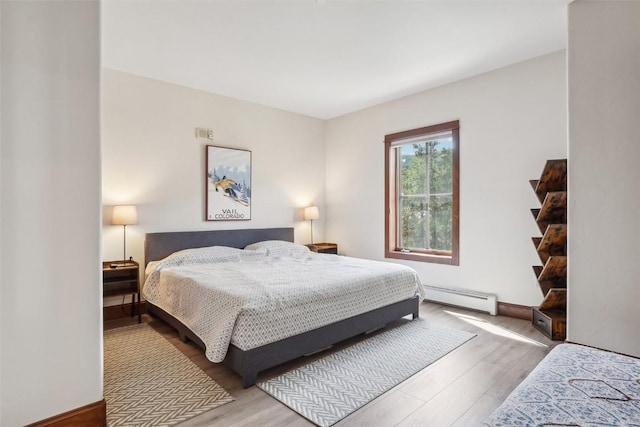 22787 US Highway 6 Unit 302, Keystone, CO 80435 - bedroom with a baseboard heating unit, wood finished floors, and baseboards