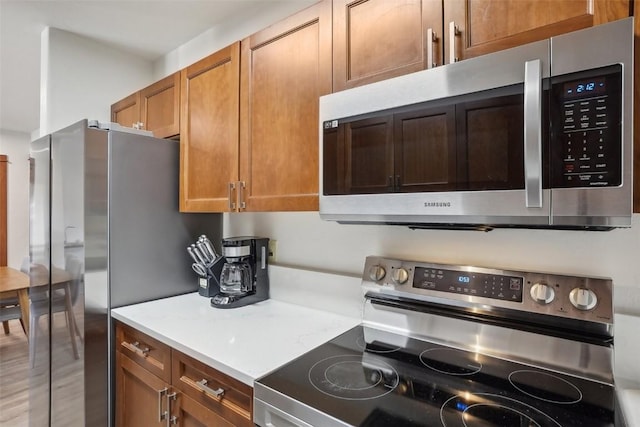 22787 US Highway 6 Unit 302, Keystone, CO 80435 - kitchen featuring appliances with stainless steel finishes, light countertops, and brown cabinets