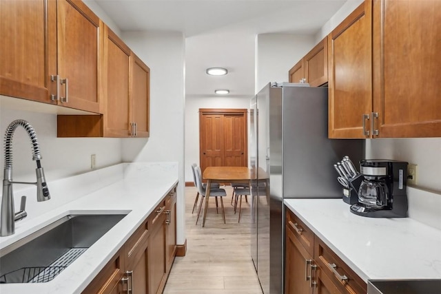 22787 US Highway 6 Unit 302, Keystone, CO 80435 - kitchen with a sink, brown cabinetry, and light wood-style flooring