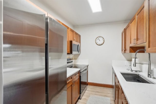 22787 US Highway 6 Unit 302, Keystone, CO 80435 - kitchen with appliances with stainless steel finishes, a sink, light wood-style floors, light countertops, and brown cabinetry
