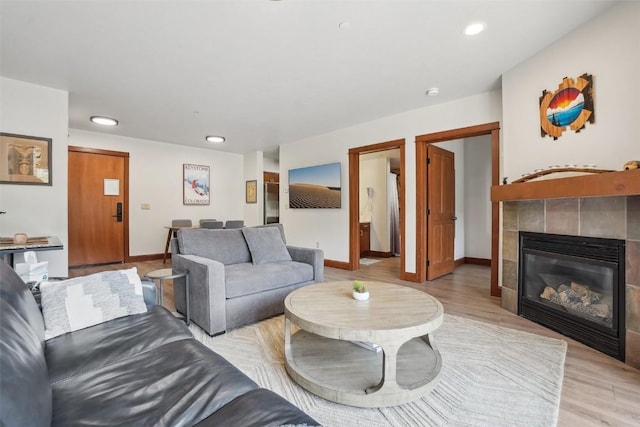 22787 US Highway 6 Unit 302, Keystone, CO 80435 - living area with baseboards, light wood-type flooring, a tile fireplace, and recessed lighting