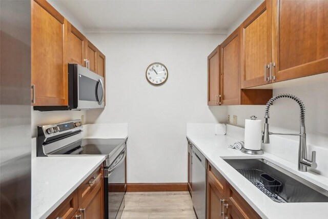 22787 US Highway 6 Unit 302, Keystone, CO 80435 - kitchen with appliances with stainless steel finishes, a sink, brown cabinets, light countertops, and baseboards