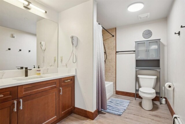 22787 US Highway 6 Unit 302, Keystone, CO 80435 - full bath featuring a baseboard radiator, vanity, toilet, wood finished floors, and shower / bathtub combination with curtain