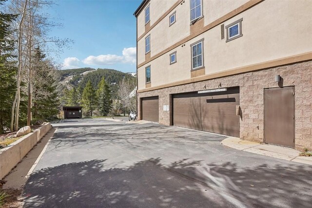 22787 US Highway 6 Unit 302, Keystone, CO 80435 - view of side of home with an attached garage, driveway, and stucco siding