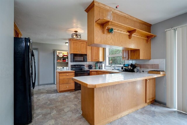 951 Alta Vista Dr, Craig, CO 81625 - kitchen featuring black appliances, a peninsula, a sink, open shelves, and tile countertops