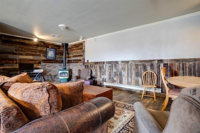 951 Alta Vista Dr, Craig, CO 81625 - living area with a wood stove, wood walls, crown molding, wood finished floors, and a baseboard heating unit