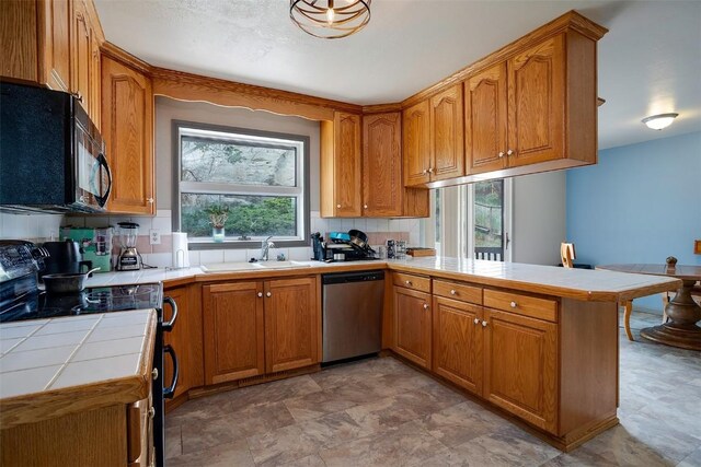 951 Alta Vista Dr, Craig, CO 81625 - kitchen with dishwasher, black microwave, range with electric stovetop, a peninsula, and tile counters