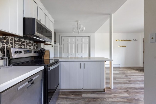 180 Evergreen Rd Unit 105, Dillon, CO 80435 - kitchen with appliances with stainless steel finishes, a peninsula, white cabinetry, a chandelier, and light wood-style floors