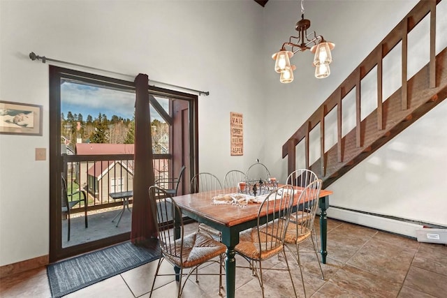 dining room with a chandelier, a baseboard radiator, baseboards, and a high ceiling