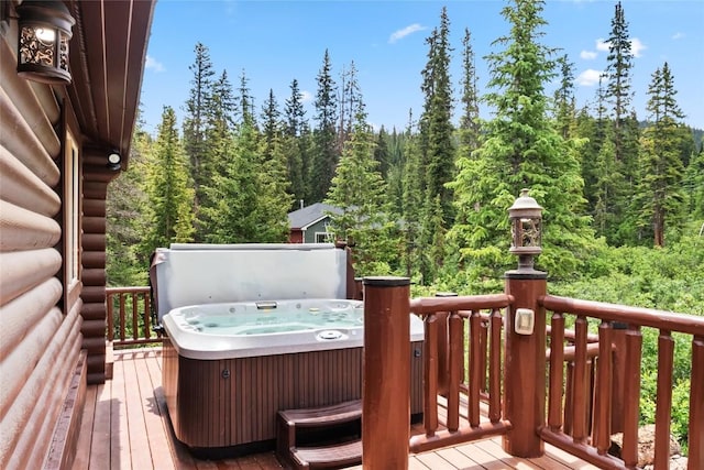 wooden terrace with a forest view and a hot tub