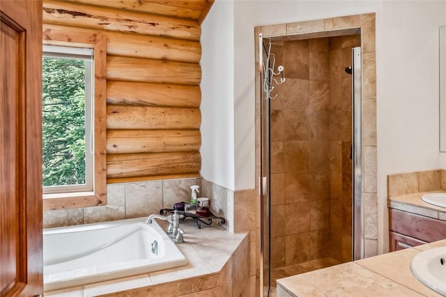 bathroom with log walls, a stall shower, vanity, and a garden tub