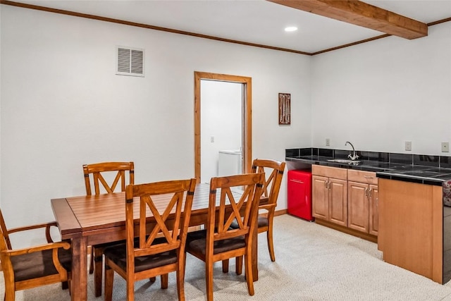 dining room featuring crown molding, light colored carpet, bar with sink, recessed lighting, and beam ceiling