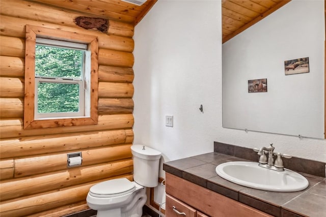 bathroom with log walls, toilet, vanity, and wood ceiling