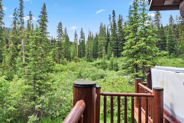 view of yard featuring a wooded view and a balcony