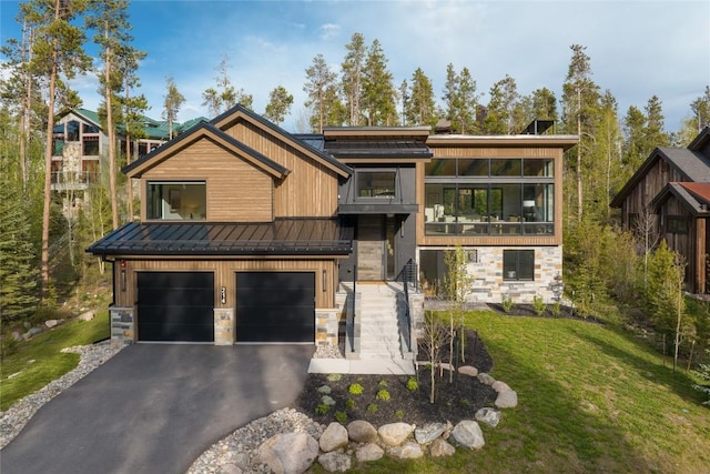 214 Windflower Ln, Frisco, CO 80443 - contemporary home featuring stone siding, a standing seam roof, a garage, asphalt driveway, and a front yard
