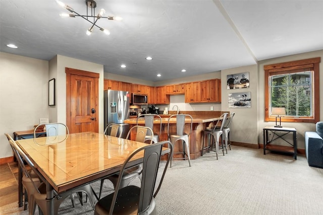 dining area featuring light colored carpet, baseboards, a chandelier, and recessed lighting