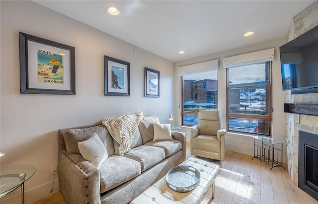 1090 Blue River Pkwy Unit 203, Silverthorne, CO 80498 - living area with wood-type flooring, a stone fireplace, and recessed lighting