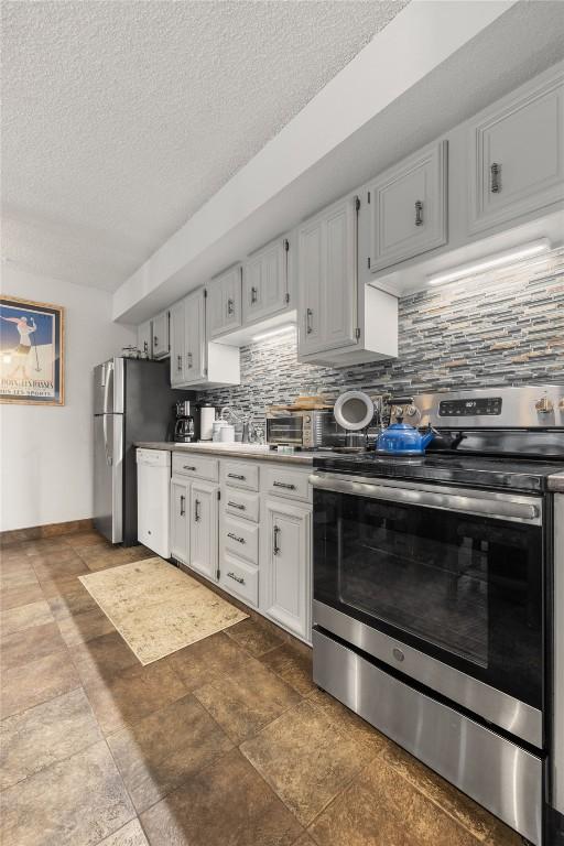 1179 Ski Hill Rd Unit 147, Breckenridge, CO 80424 - kitchen with a textured ceiling, baseboards, appliances with stainless steel finishes, and decorative backsplash
