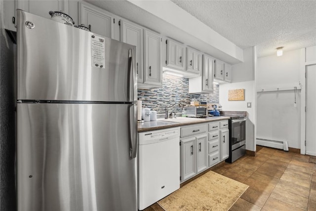 1179 Ski Hill Rd Unit 147, Breckenridge, CO 80424 - kitchen with appliances with stainless steel finishes, a sink, baseboard heating, a textured ceiling, and backsplash