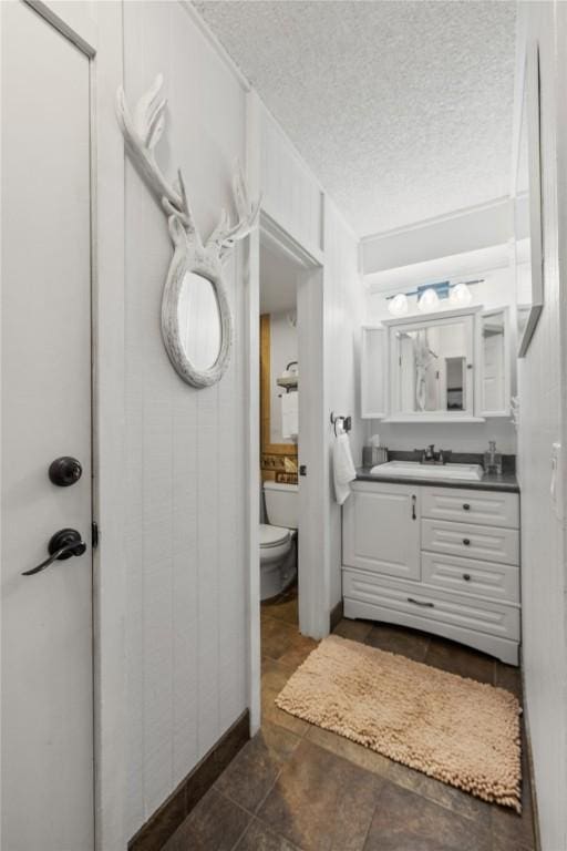 1179 Ski Hill Rd Unit 147, Breckenridge, CO 80424 - bathroom featuring toilet, a textured ceiling, baseboards, and vanity