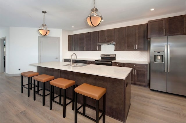 37 W 4th St Unit 201E, Silverthorne, CO 80498 - kitchen featuring stainless steel appliances, under cabinet range hood, light wood finished floors, dark brown cabinetry, and recessed lighting