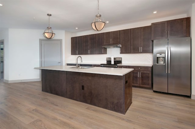 kitchen with under cabinet range hood, stainless steel appliances, a sink, dark brown cabinetry, and light wood-style flooring
