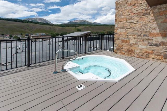 view of pool featuring hot tub deck surround and a mountain view